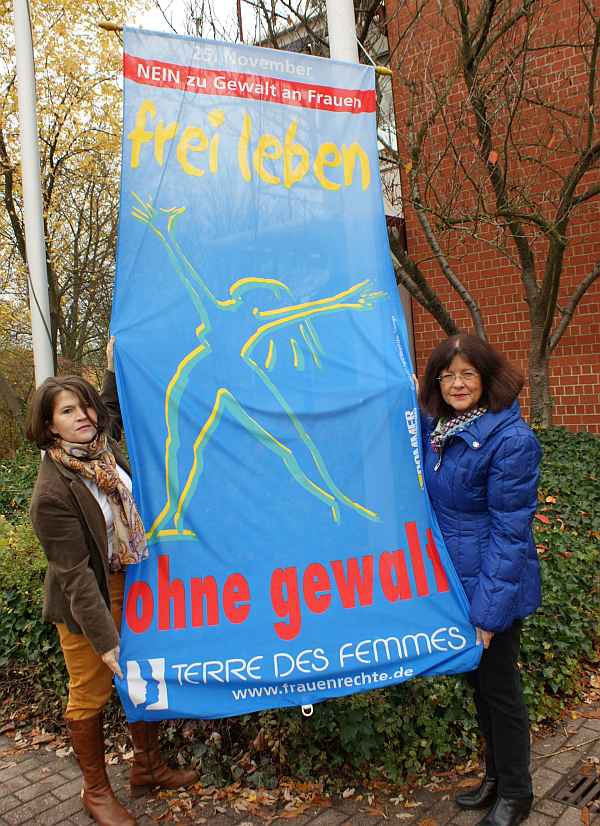 Frauenbeauftrage Barbara Dees und Landrätin Theresia Riedmaier hissen die Fahne „Frei leben – ohne Gewalt“ am Kreishaus der Südlichen Weinstraße.